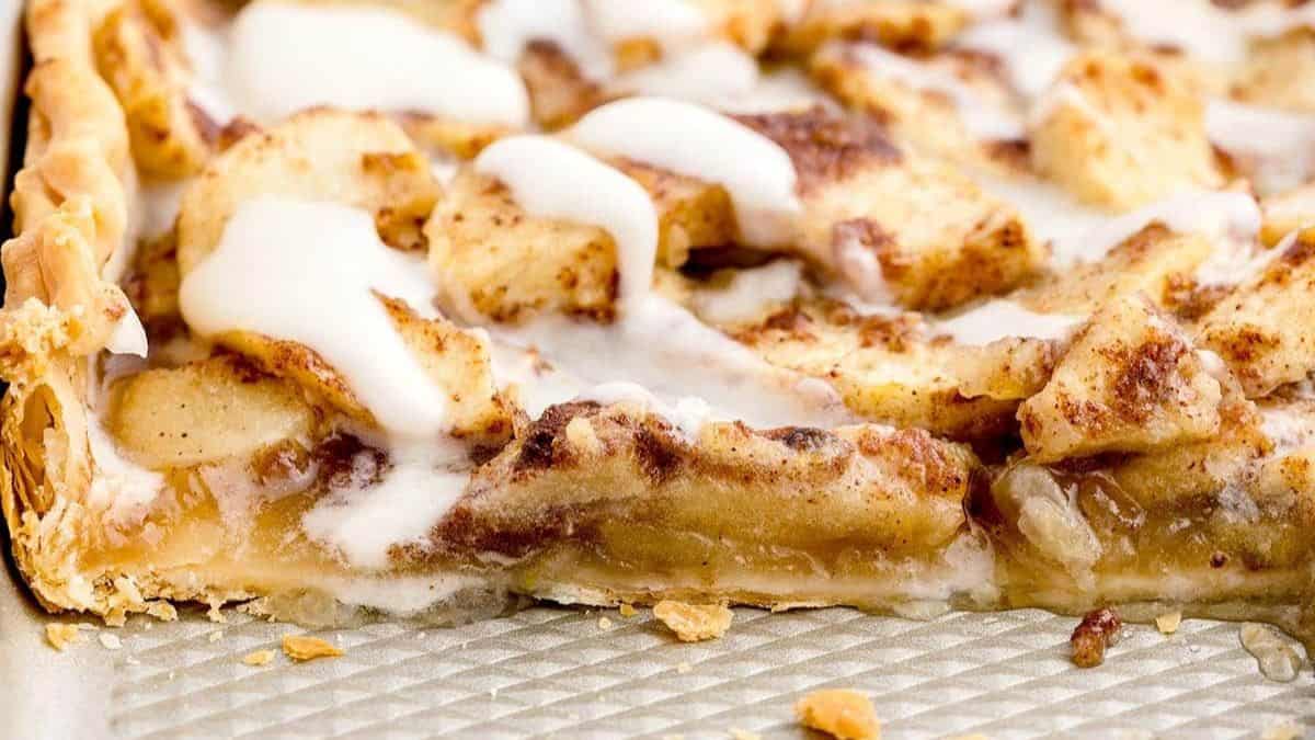 apple slab pie in a baking sheet topped with icing