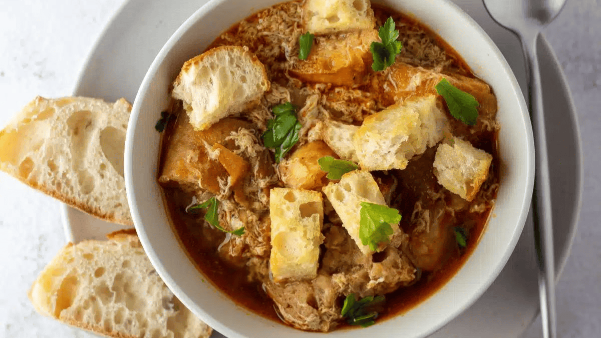 a bowl of garlic soup with croutons on top