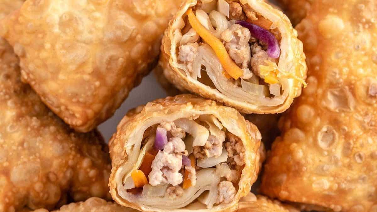 cut in half fried egg rolls filled with ground pork and veggies