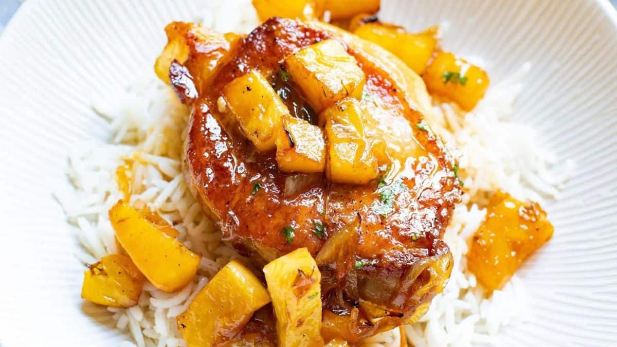 glazed pork chops laid over white rice and topped with cubed pineapple