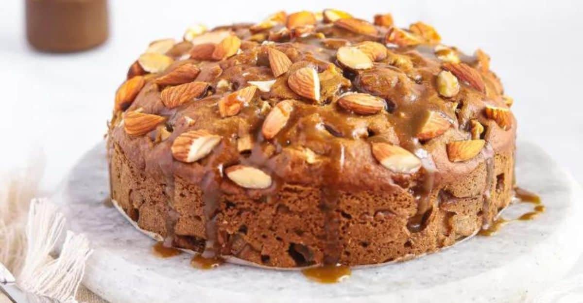 whole apple cake topped with toffee sauce and almonds