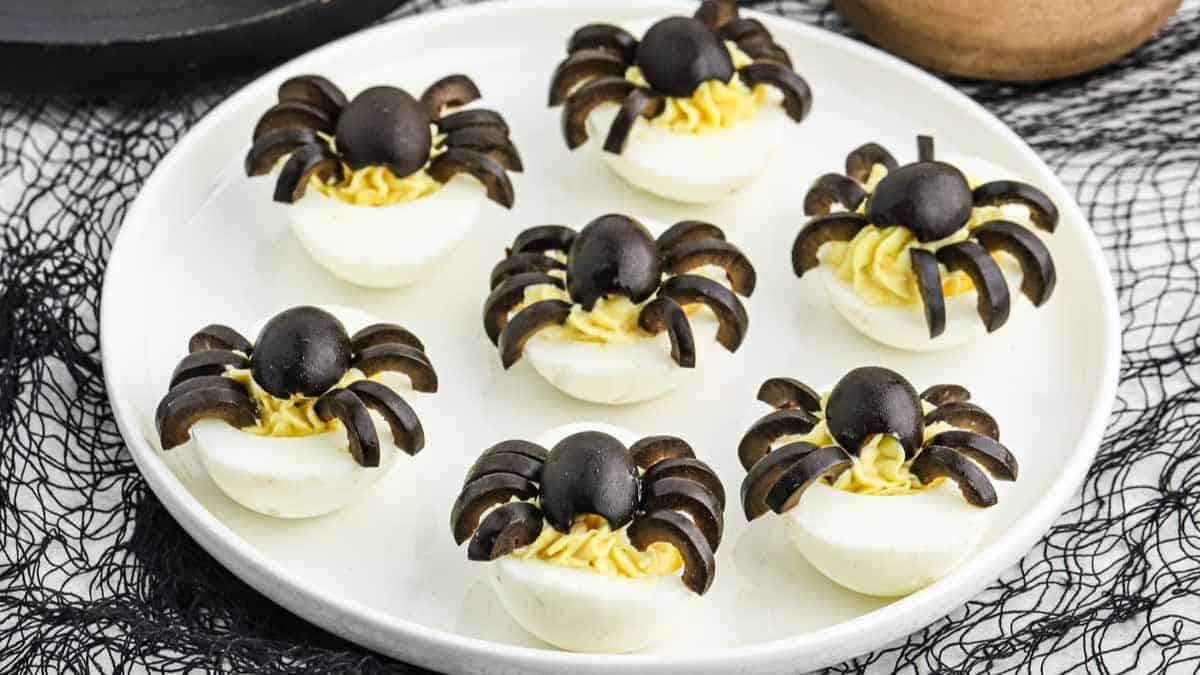 deviled eggs topped with spiders made with black olives