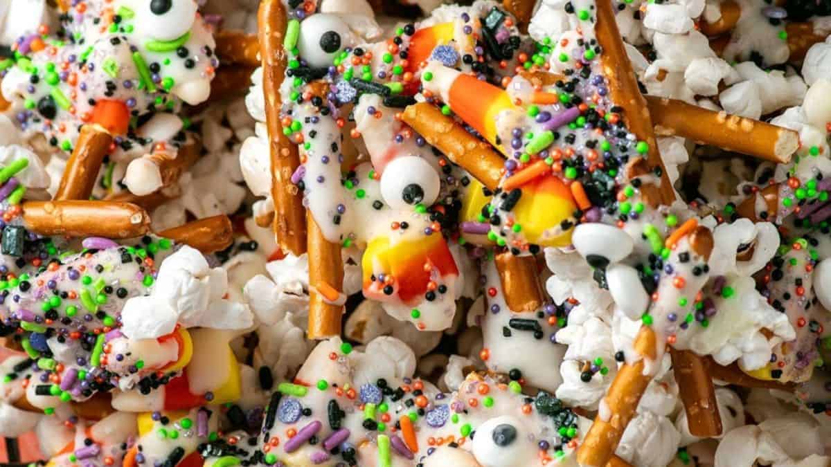 bowl of halloween snack mix with pretzel, popcorn, candy, and sprinkles