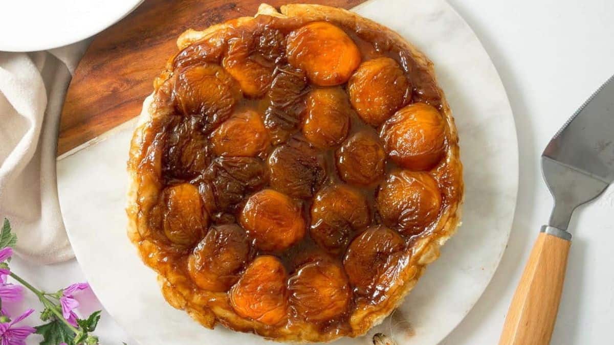 whole peach tarte tatin on a serving board