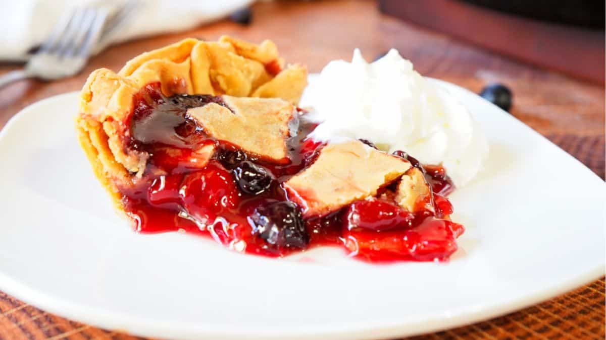 a slice of pie with blueberries and cherry filling 