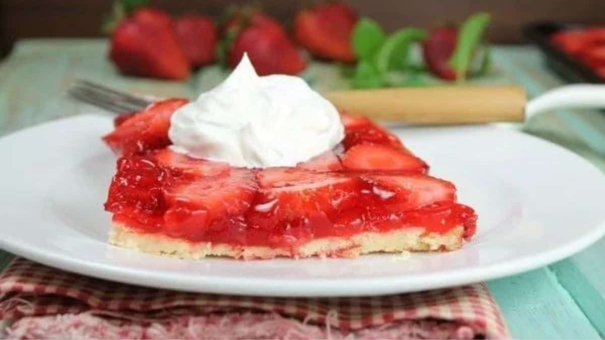 a slice of strawberry jello pie topped with a dollop of whipped cream