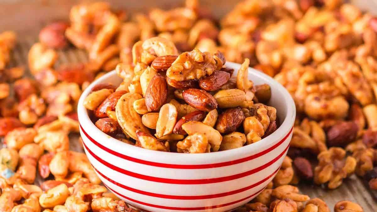 a striped bowl with a mix of roasted nuts