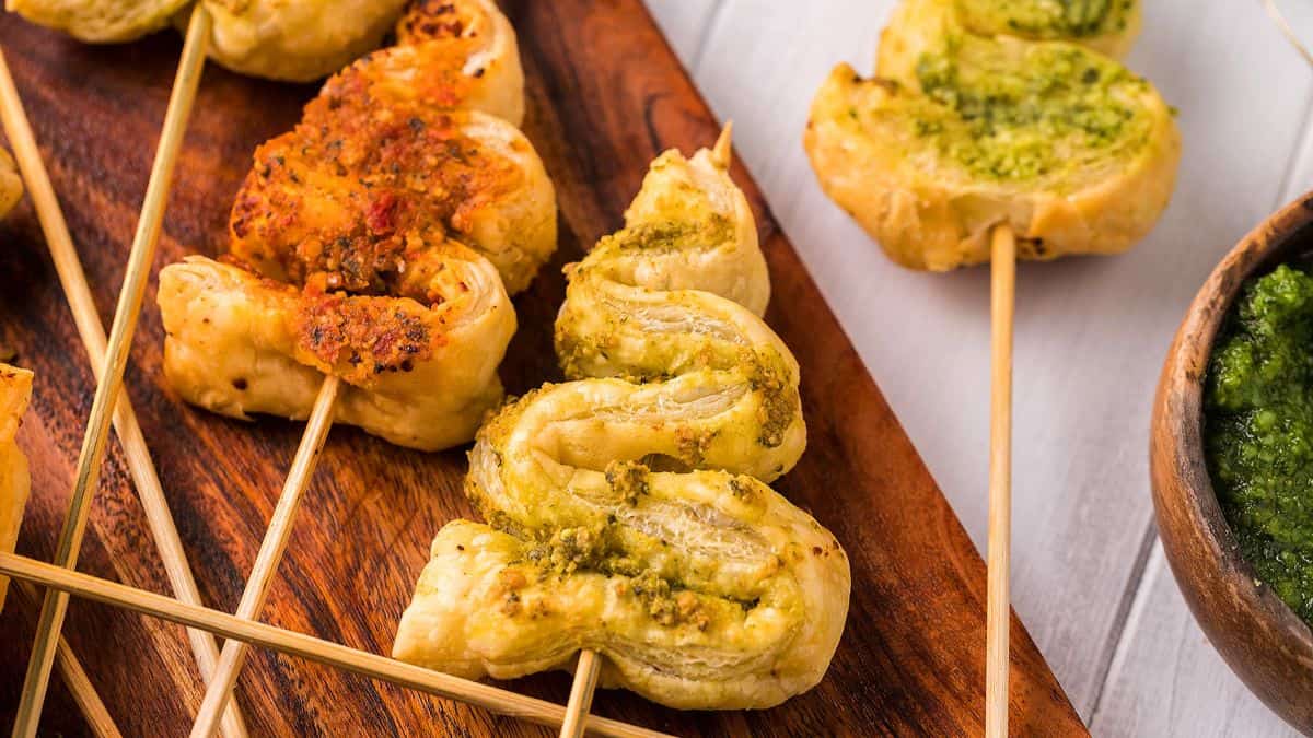 puff pastry strips on skewers shaped like christmas trees and coated in pesto