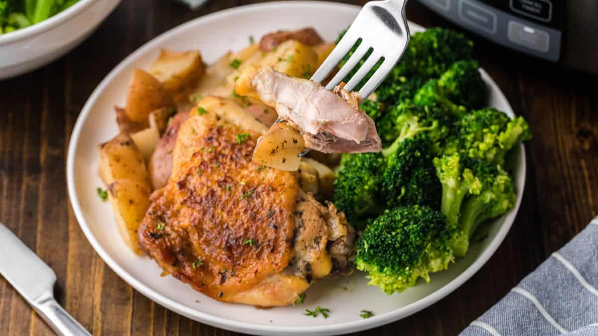 Plated slow cooker ranch chicken and red potatoes with broccoli on the sides.
