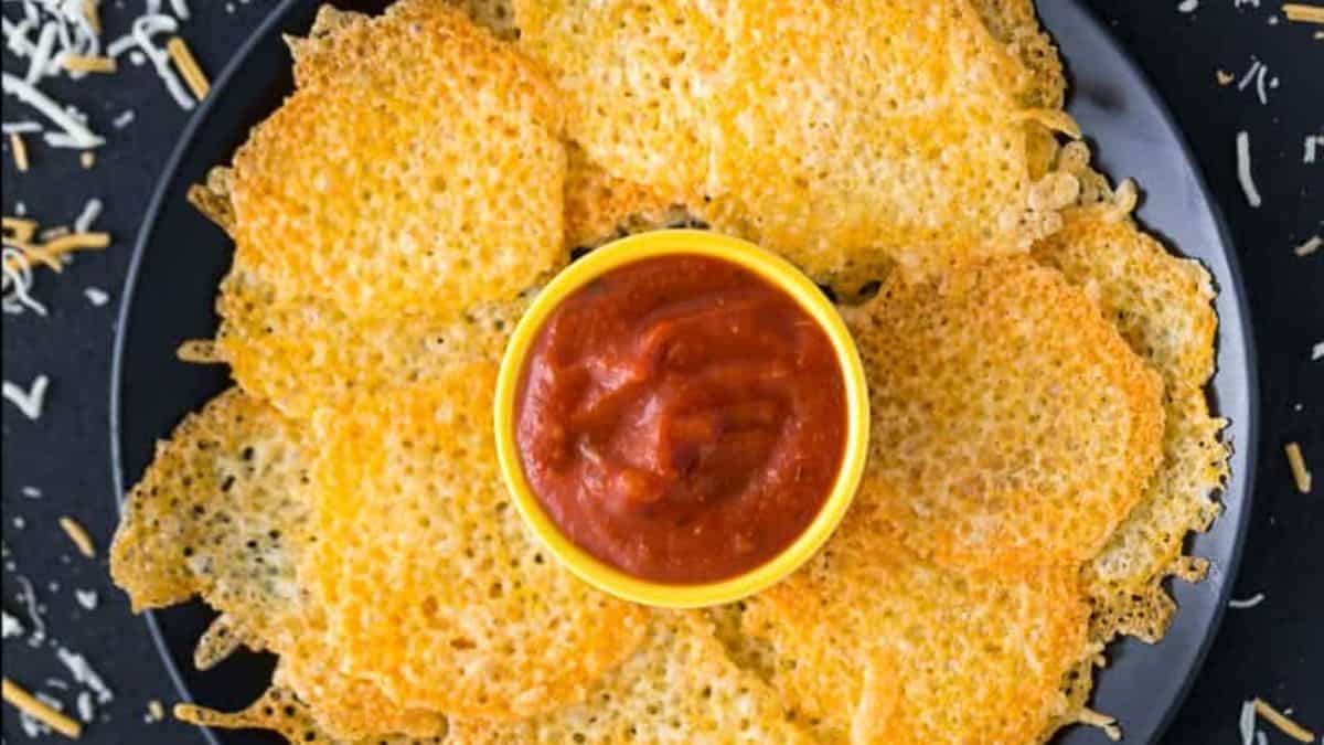 A plate of cheese chips with dip in the center.