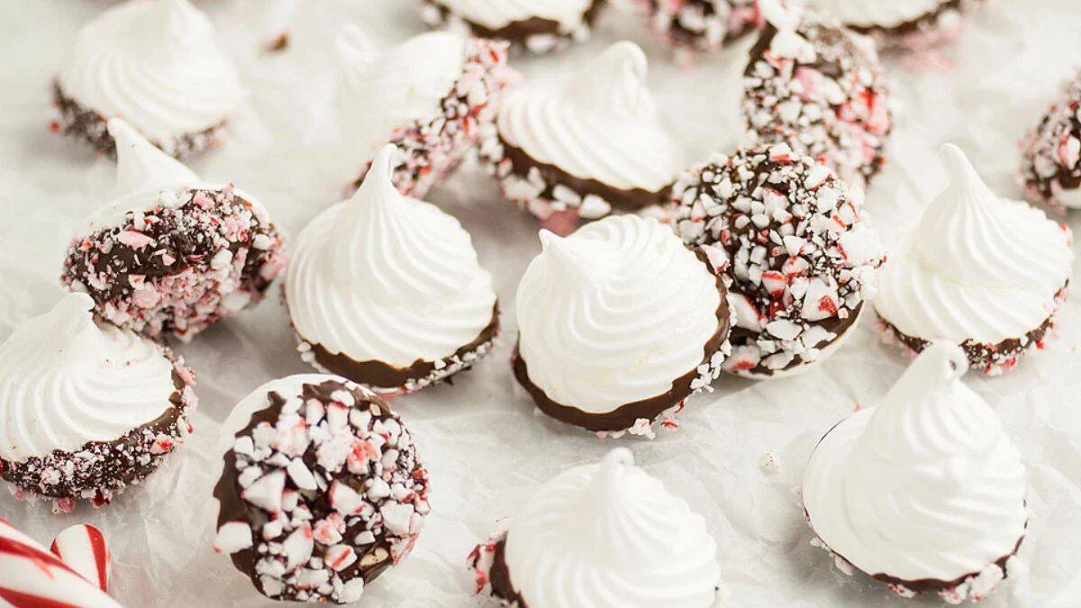 A batch of dipped peppermint meringue kiss Christmas cookies.