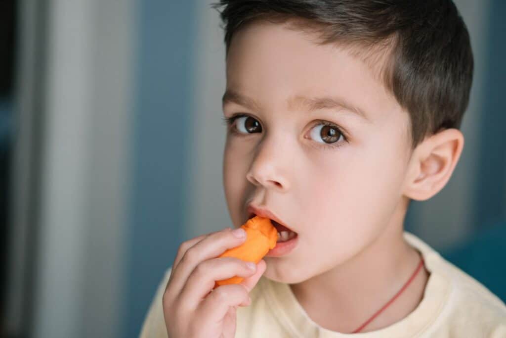 Cute kid eating a carrot