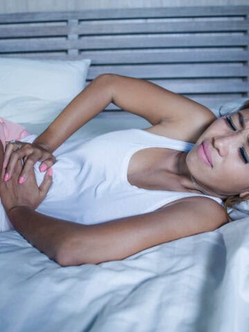 woman laying down with an upset stomach