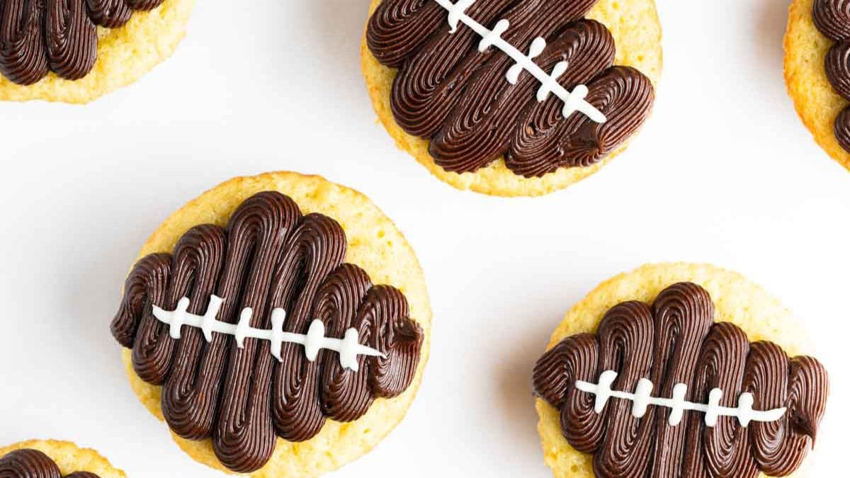 Flat laid  football cupcakes with beer in white table.