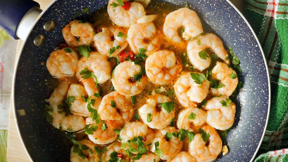 Freshly cooked gambas pil pil garnished with fresh parsley.