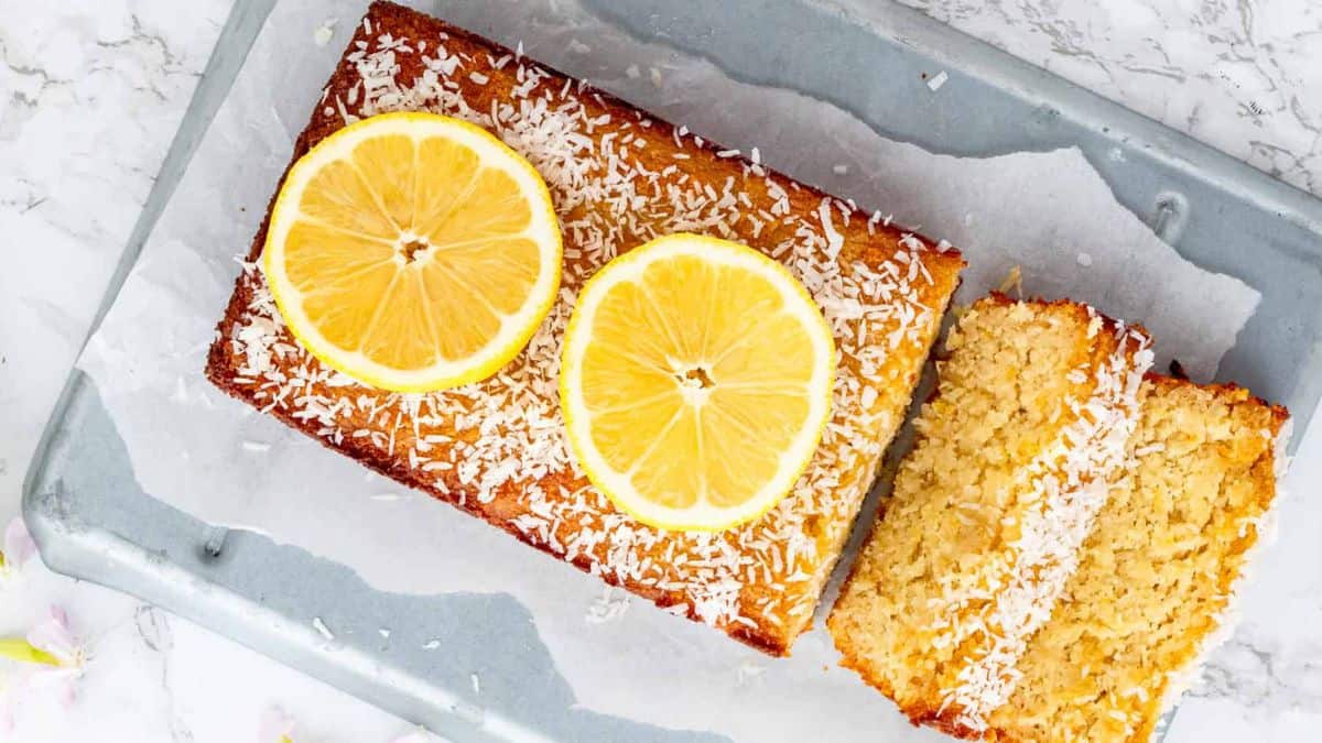 Sliced lemon coconut bread with sliced of fresh lemon on top.