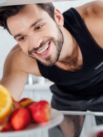 Man looking happily inside the fridge
