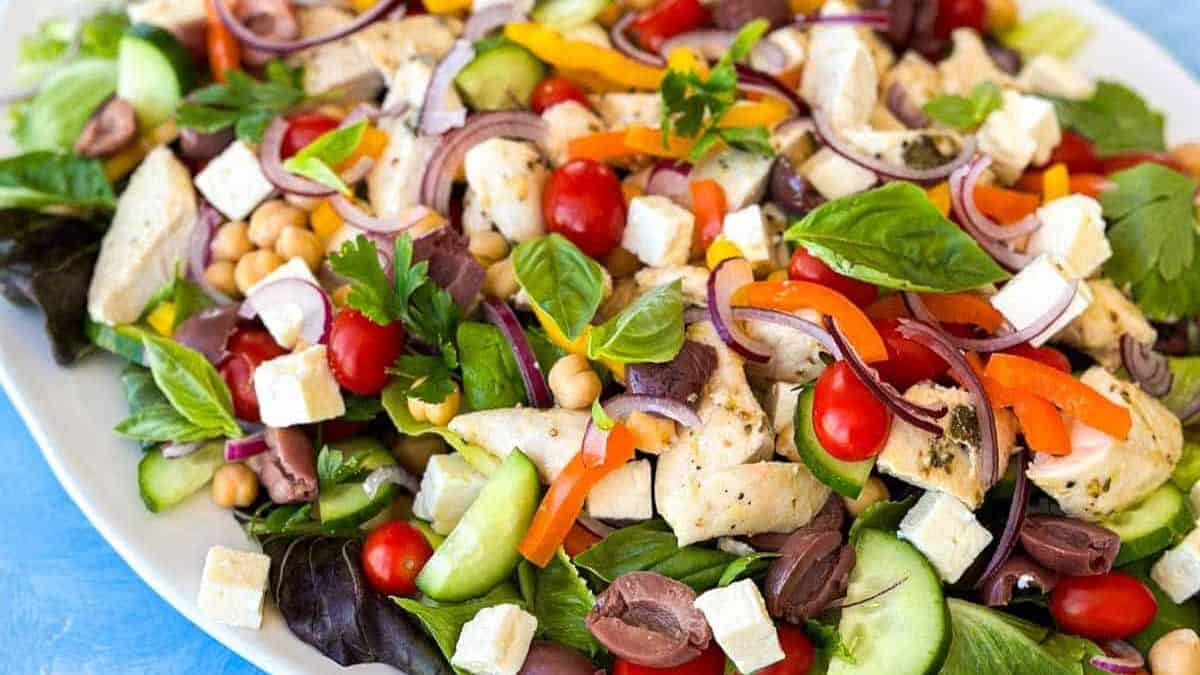 A plate of Mediterranean chicken salad with Greek dressing.