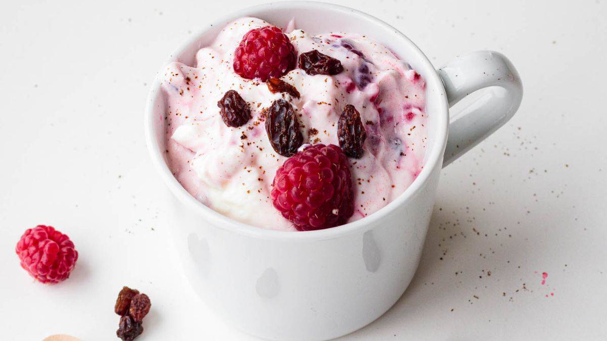 A cup of delicious Norwegian ice cream with raspberries.