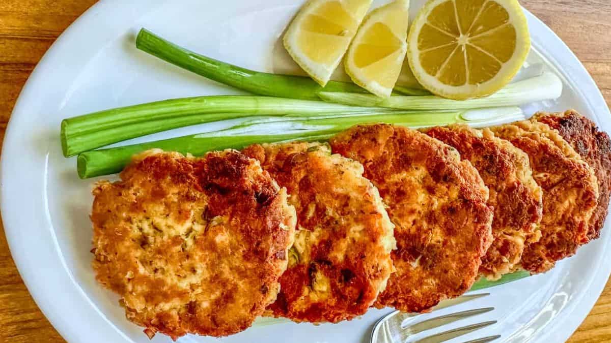 Salmon Patties served with onion spring and sliced lemon.
