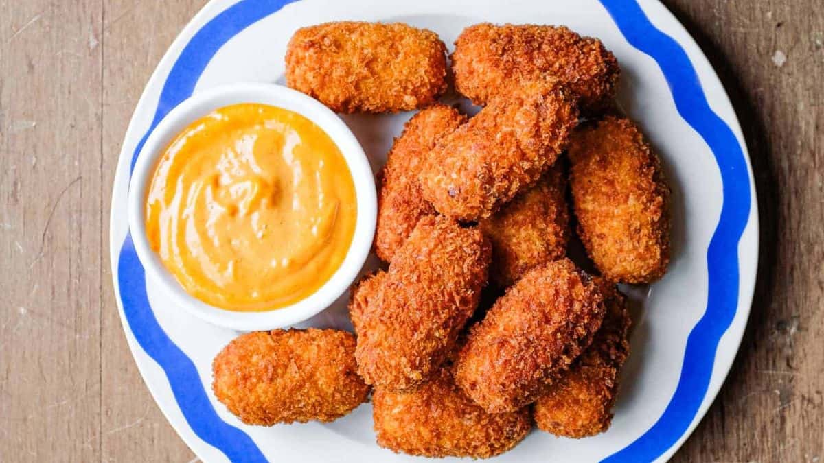 Freshly cooked Spanish jamon croquetas with dip on the side.