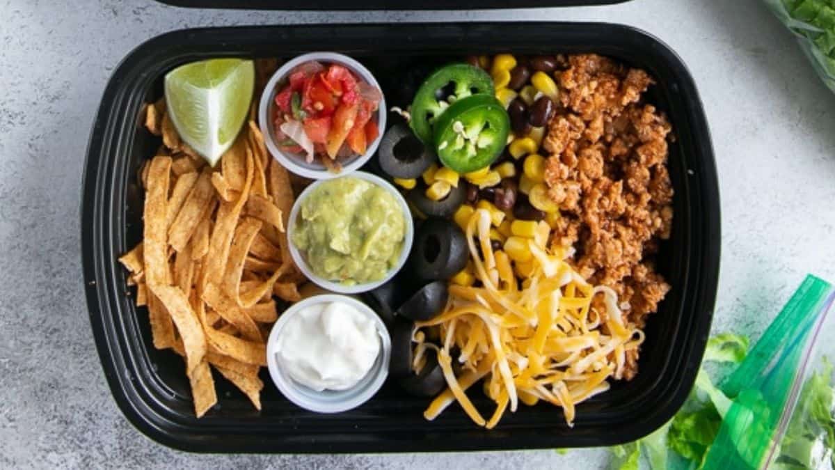 Taco salad meal prep in a black meal box.
