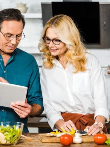 couple looking at a tablet while cooking