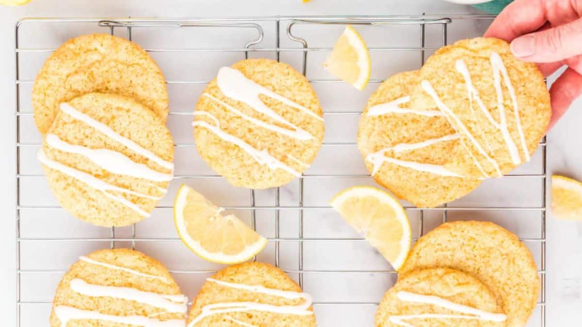 Gluten-free almond flour lemon cookies in a cooling rock with slices of lemon.