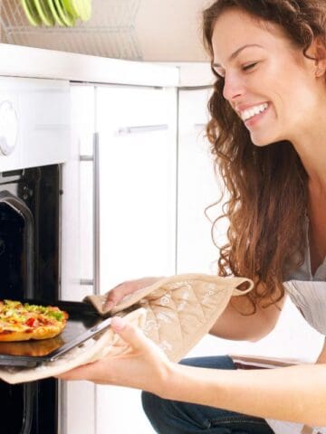 taking out a pizza from the oven
