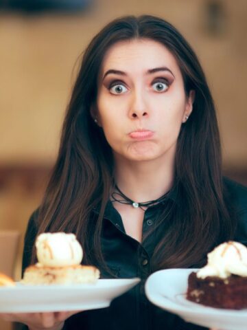 woman holding two big plates of dessert