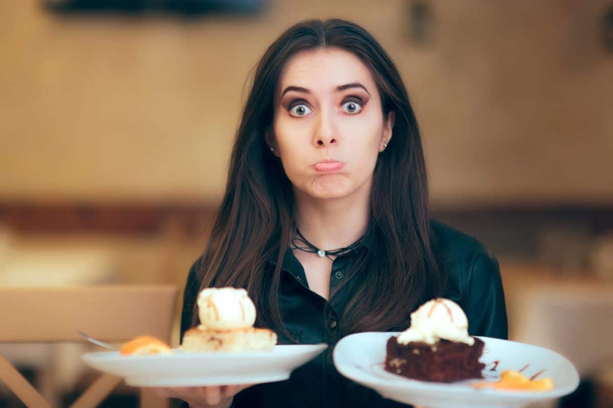 woman holding two big plates of dessert