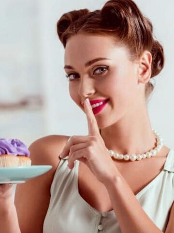woman shows shh with cupcakes