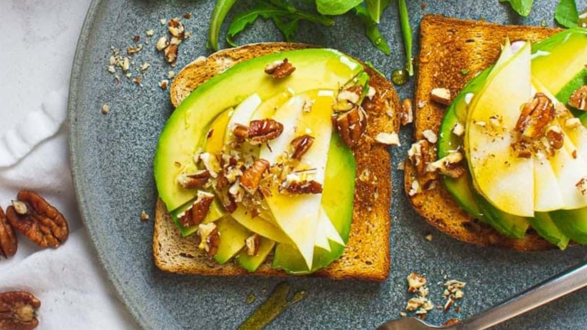 Avocado toast with pear and honey with walnuts on top.