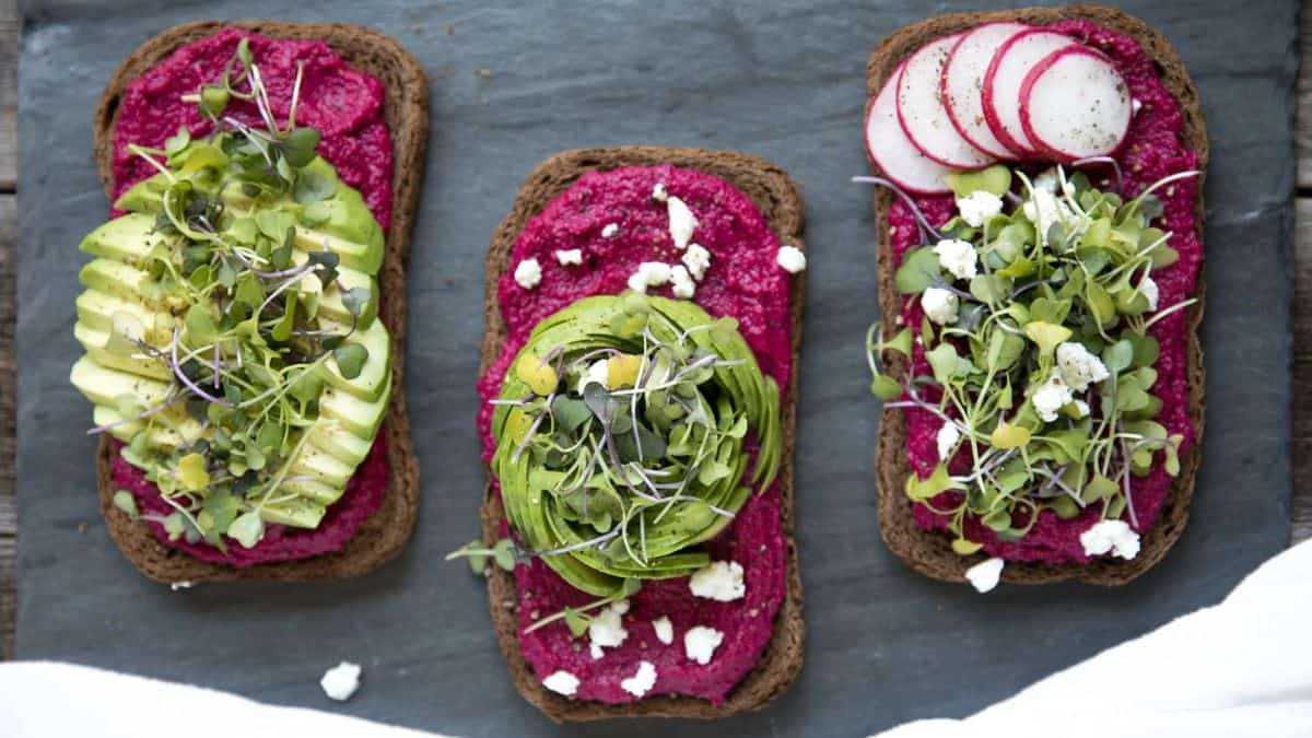 Colorful beet hummus avocado toast.