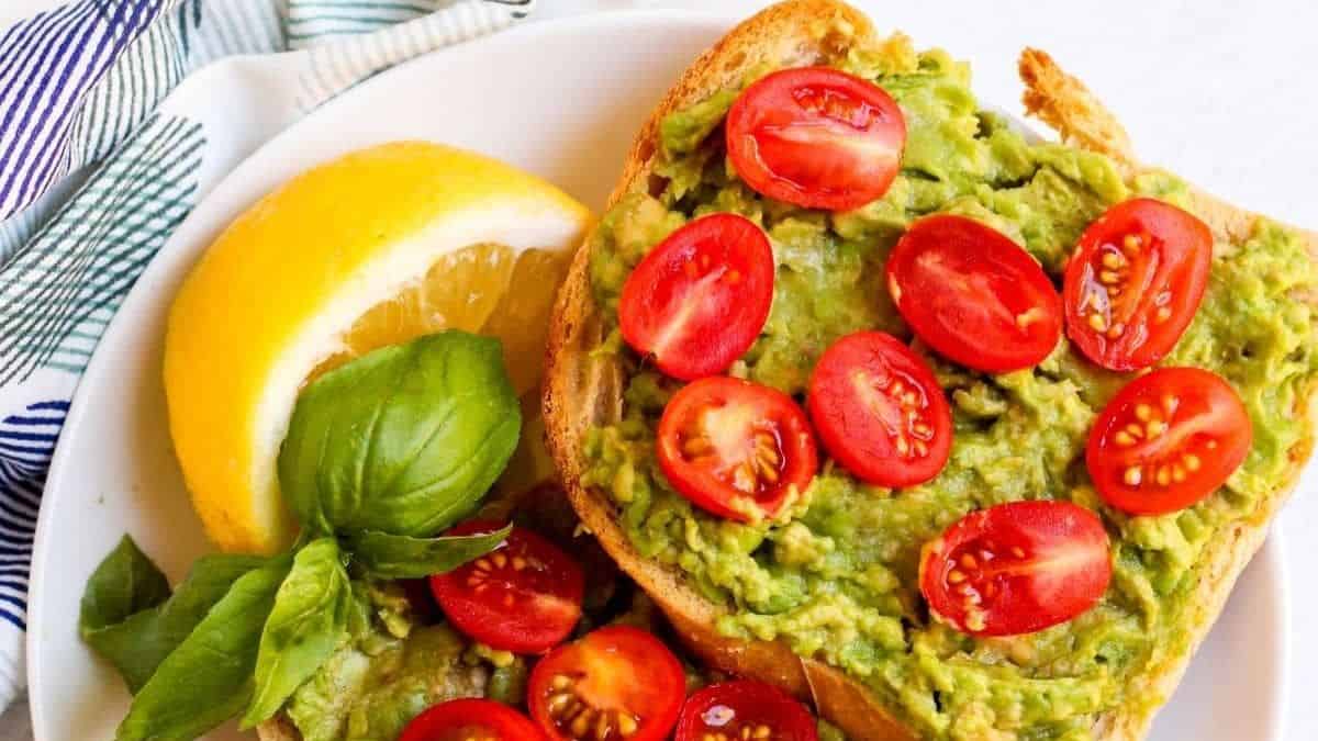 Cherry tomato avocado toast with lemon on the side.