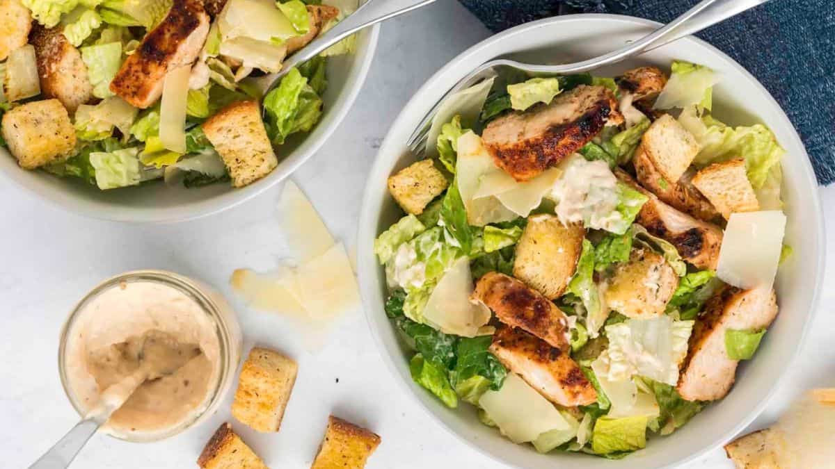 Bowls of chicken Caesar salad with homemade croutons.