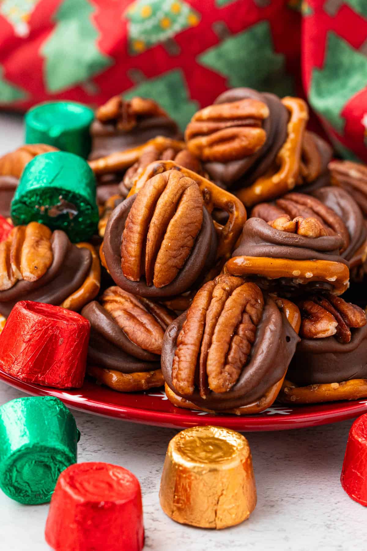 Christmas Rolo Pretzel Turtles with wrapped rolo candies on a red plate