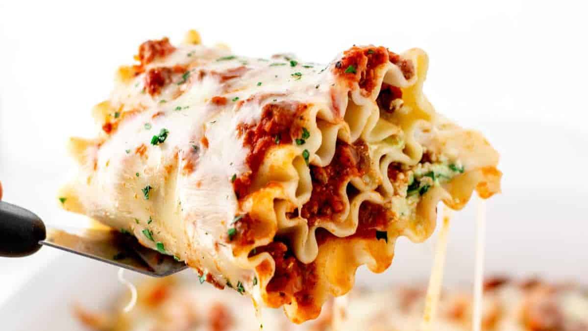 A serving of hidden veggie lasagna roll ups with visible cheese pull.