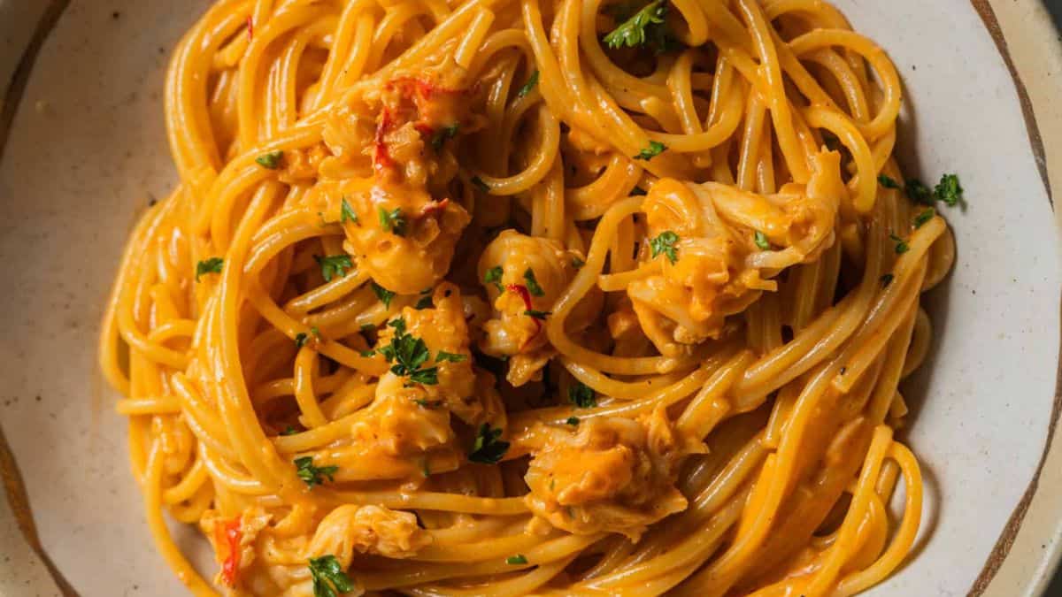 A plate of lobster pasta with creamy saffron sauce.