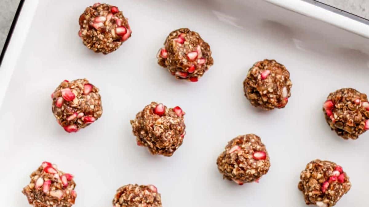 Oat bliss balls with dates + pomegranate in a tray.