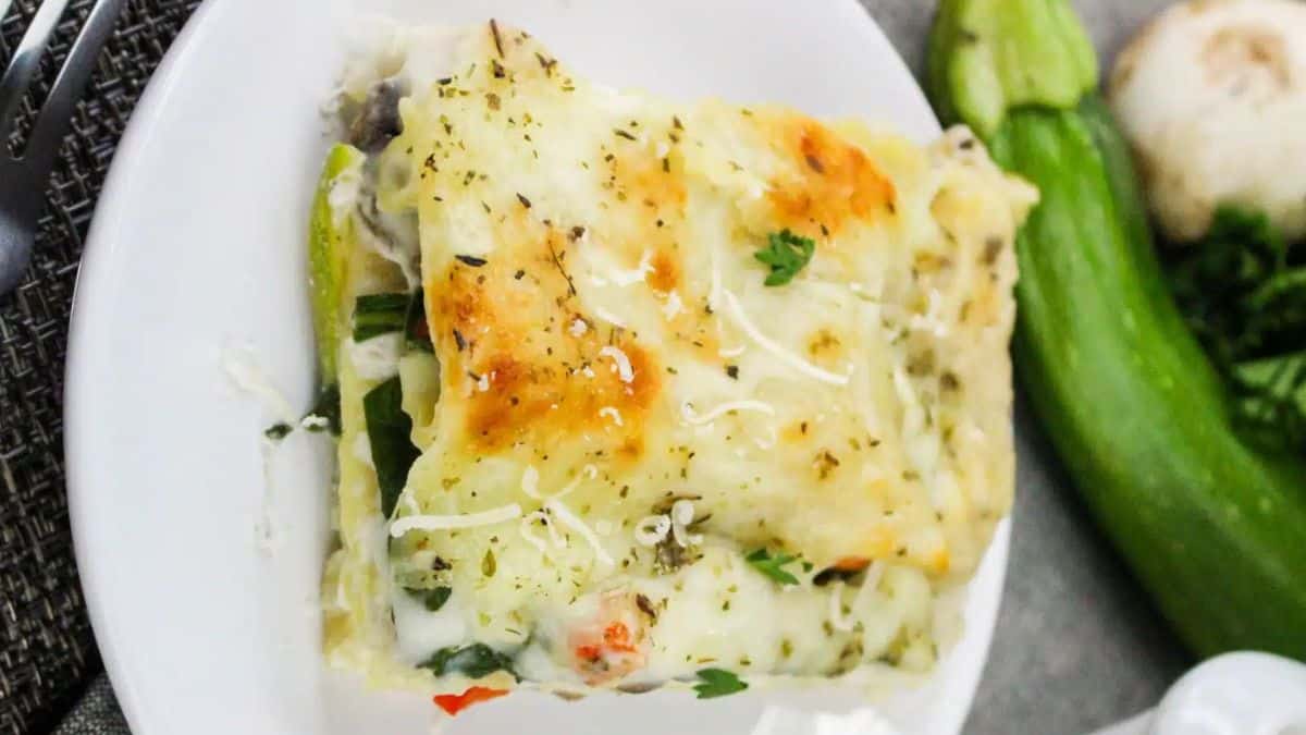 A sliced of vegetable lasagna in white sauce
