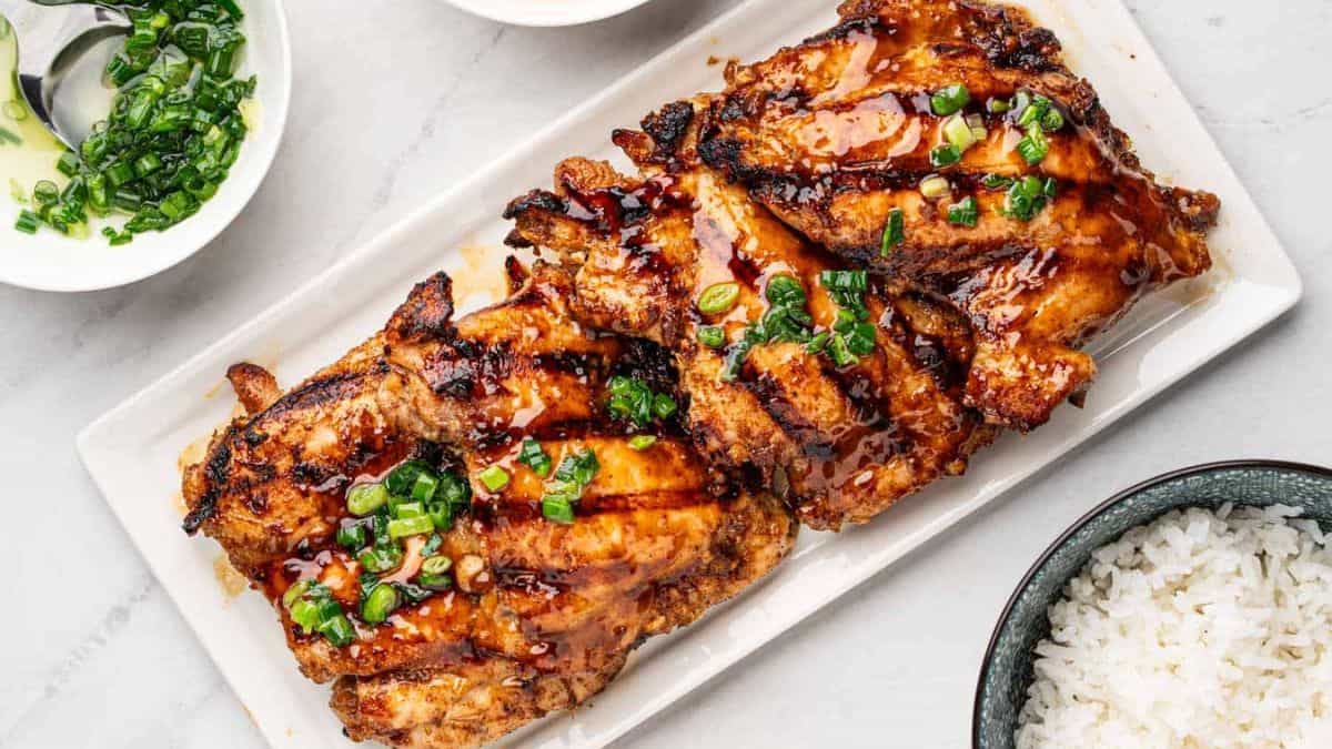 Vietnamese lemongrass chicken in a plate served with rice on a separate bowl.