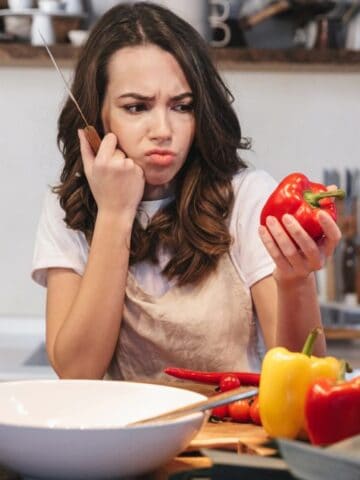 confused woman looking at pepper cooking