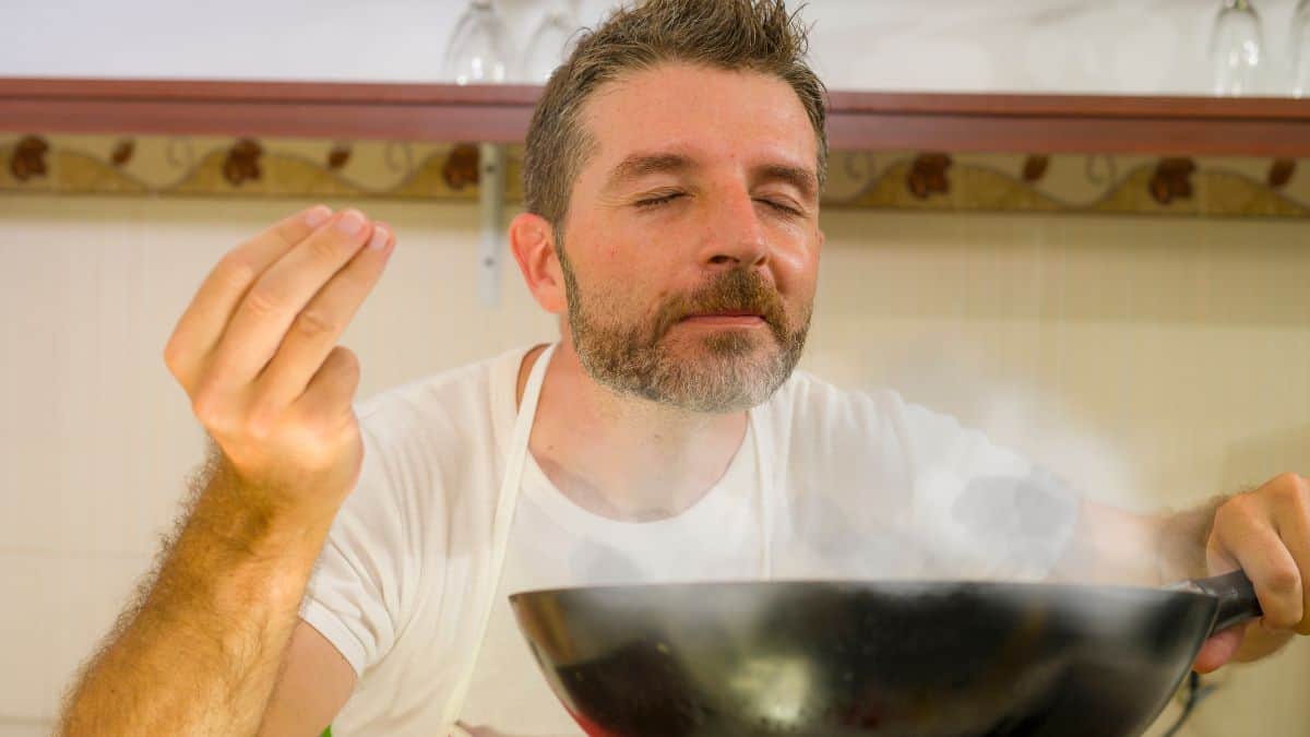 man cooking and smelling food