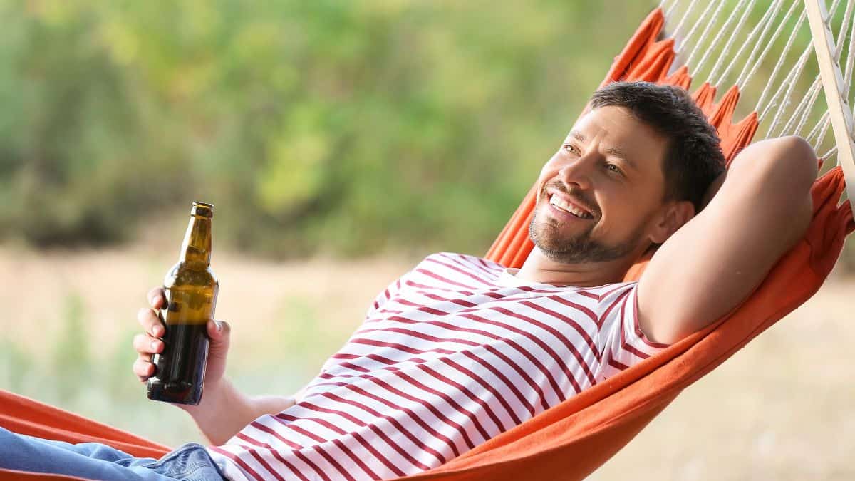 man drinking on hammock