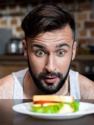 man looking at sandwich