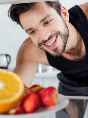 man taking food from fridge