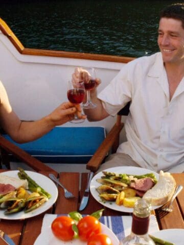 two rich people eating on a yacht