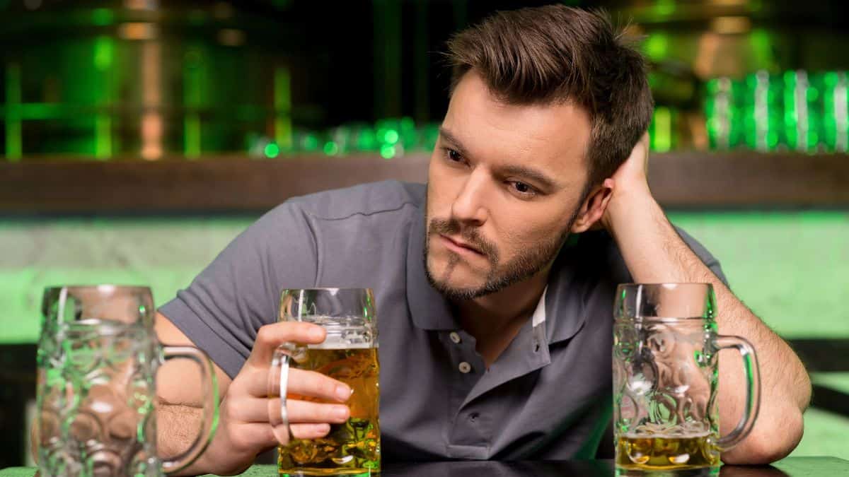 upset man at bar with beer