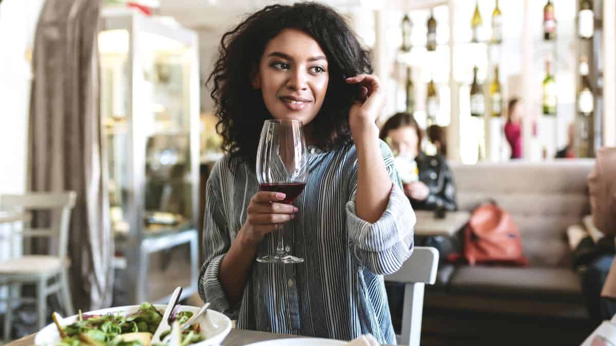 woman drinking wine with salad